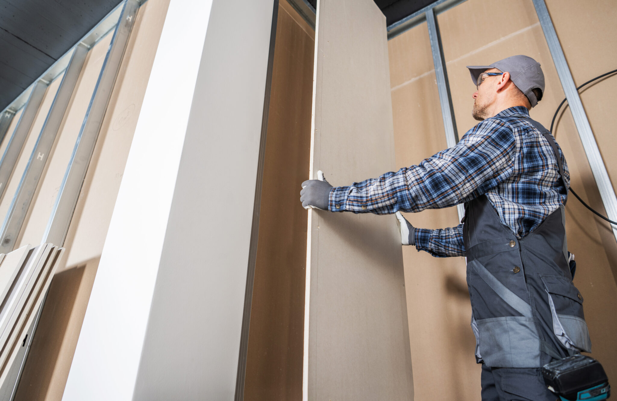 Construction Worker Fitting Piece of a Drywall KO Construction Solutions