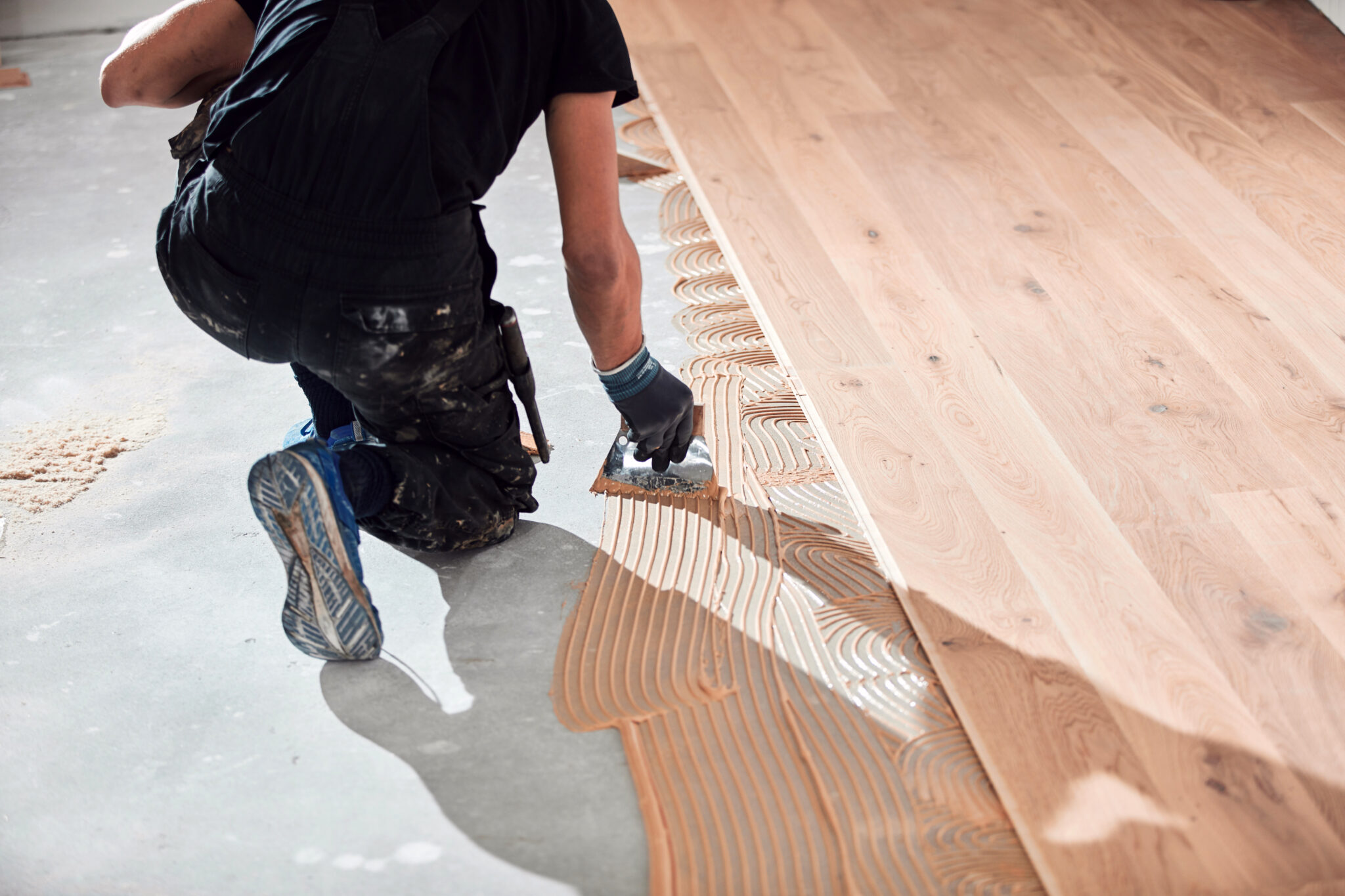 Professional handyman installing laminate flooring in a new apartment. KO Construction Solutions